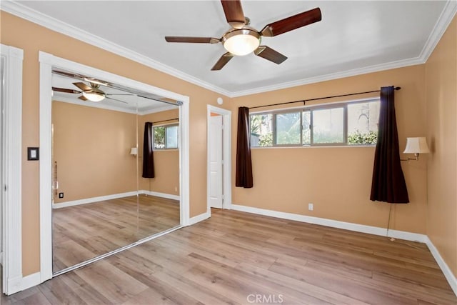 unfurnished bedroom with light wood-style floors, a closet, ornamental molding, and baseboards