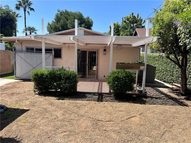 view of front of home featuring fence and stucco siding