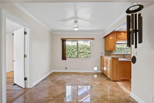 interior space featuring ceiling fan, baseboards, and crown molding