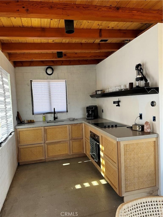 kitchen with black appliances, beamed ceiling, a sink, and light countertops