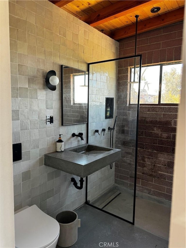 full bathroom featuring toilet, wood ceiling, finished concrete floors, beam ceiling, and tile walls