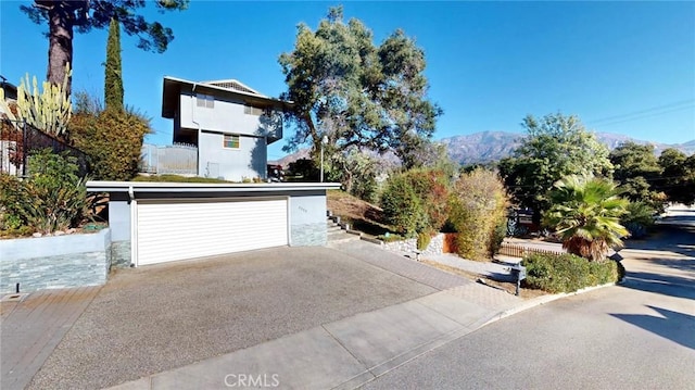 view of property exterior with a detached garage and a mountain view