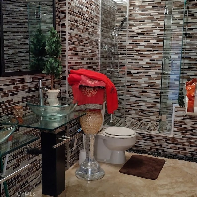 bathroom featuring toilet and tile walls