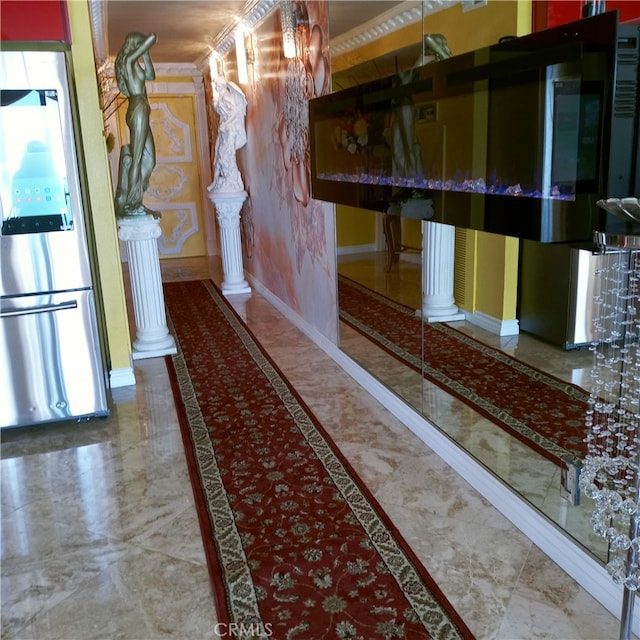 hall with ornate columns, baseboards, and marble finish floor