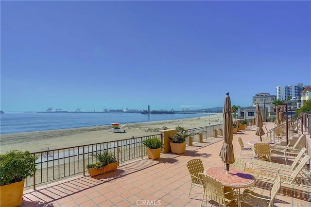 view of patio with a water view and a view of the beach