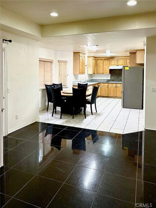dining space with baseboards, granite finish floor, and recessed lighting