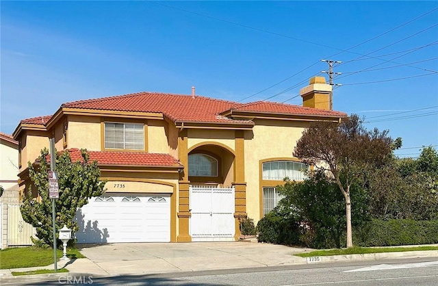 mediterranean / spanish-style home with an attached garage, stucco siding, a tile roof, fence, and driveway
