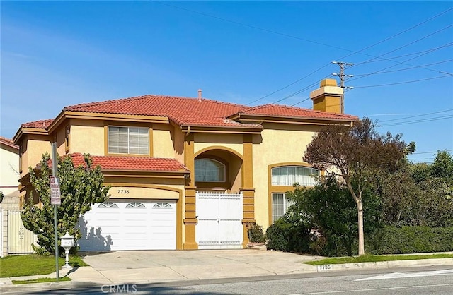 mediterranean / spanish house with a garage, stucco siding, a tile roof, fence, and driveway
