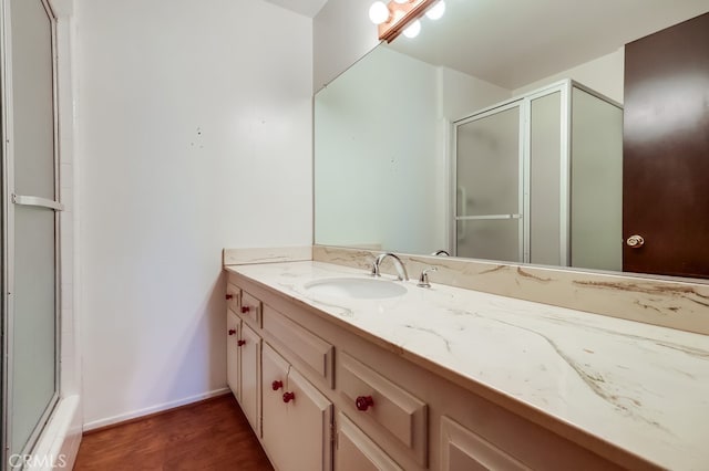 bathroom featuring baseboards, wood finished floors, and vanity