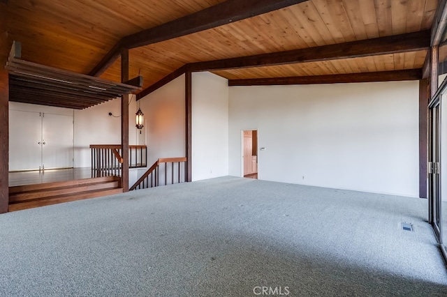 carpeted empty room with vaulted ceiling with beams and wood ceiling