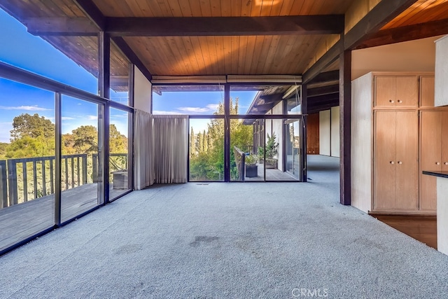 unfurnished sunroom with plenty of natural light, wood ceiling, and beamed ceiling