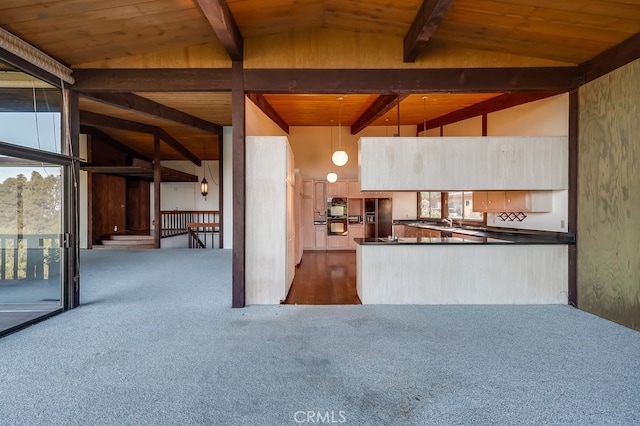 kitchen with vaulted ceiling with beams, dark colored carpet, dark countertops, and wooden ceiling