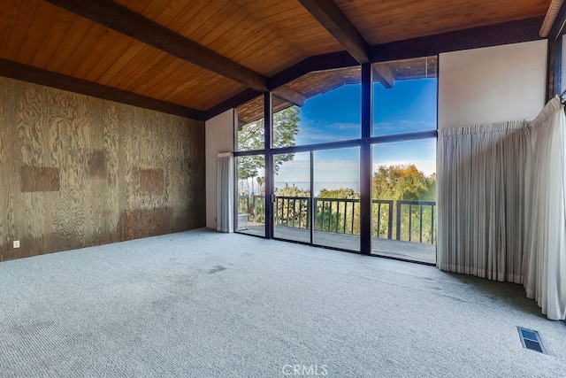 unfurnished room featuring beam ceiling, floor to ceiling windows, visible vents, wood ceiling, and wood walls