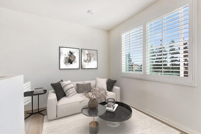 living area with light wood-style flooring and baseboards