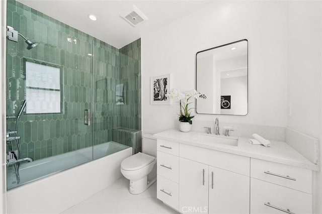 bathroom featuring tile patterned flooring, toilet, bath / shower combo with glass door, visible vents, and vanity