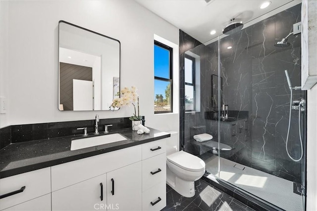 full bath featuring a marble finish shower, vanity, toilet, and recessed lighting