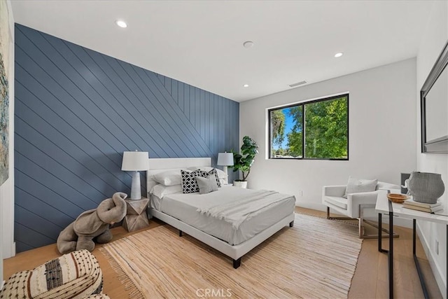 bedroom with an accent wall, visible vents, and recessed lighting