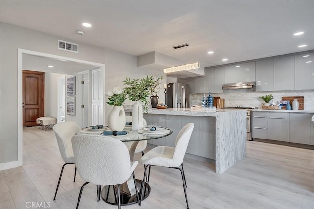 dining space with light wood finished floors, baseboards, visible vents, and recessed lighting