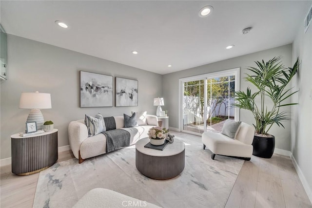 living area with light wood-type flooring, visible vents, baseboards, and recessed lighting