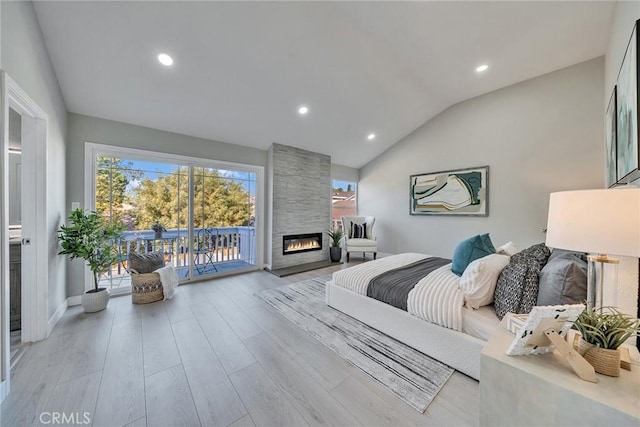 bedroom with recessed lighting, a fireplace, wood finished floors, access to exterior, and vaulted ceiling