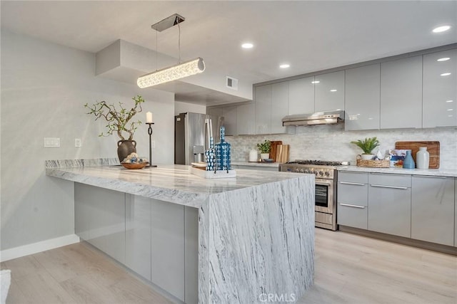 kitchen featuring modern cabinets, appliances with stainless steel finishes, a peninsula, gray cabinets, and under cabinet range hood