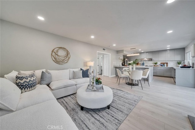 living area featuring recessed lighting, visible vents, and light wood-style flooring