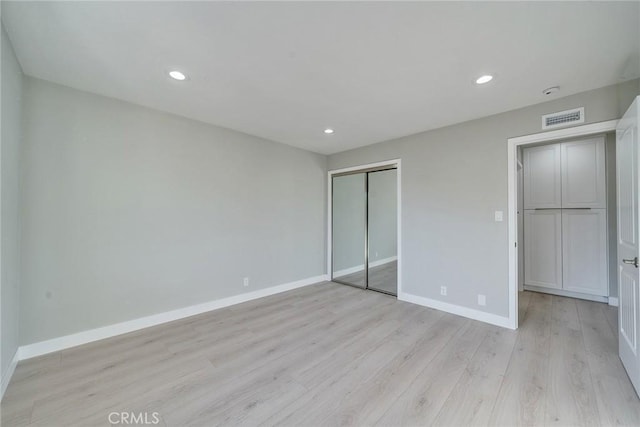 unfurnished bedroom with baseboards, visible vents, light wood-type flooring, a closet, and recessed lighting