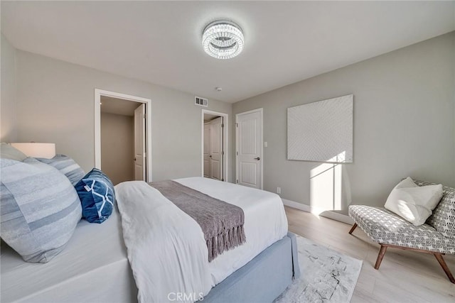 bedroom with light wood-type flooring, visible vents, and baseboards