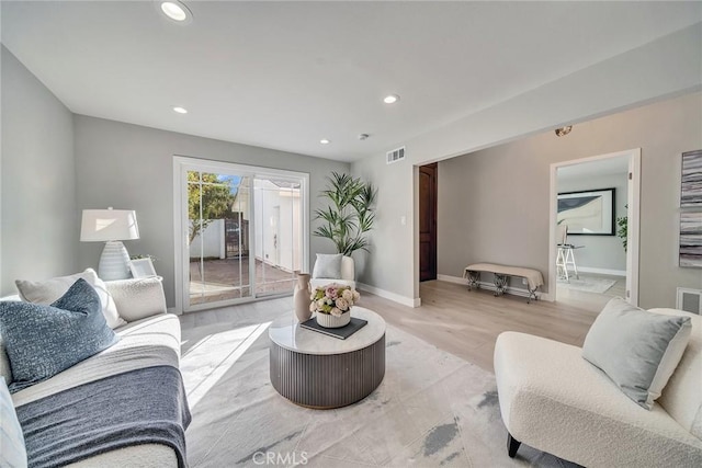 living room featuring recessed lighting, baseboards, visible vents, and light wood finished floors