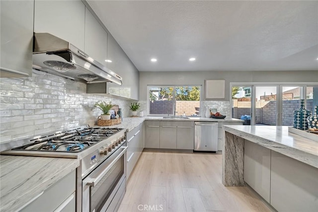 kitchen with stainless steel appliances, a wealth of natural light, gray cabinetry, and ventilation hood