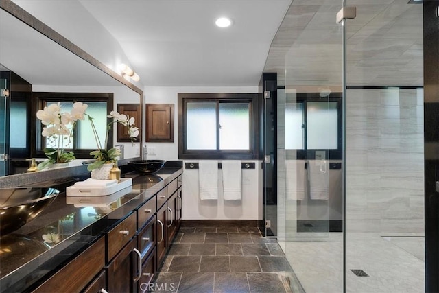 full bath with double vanity, a stall shower, a sink, and recessed lighting