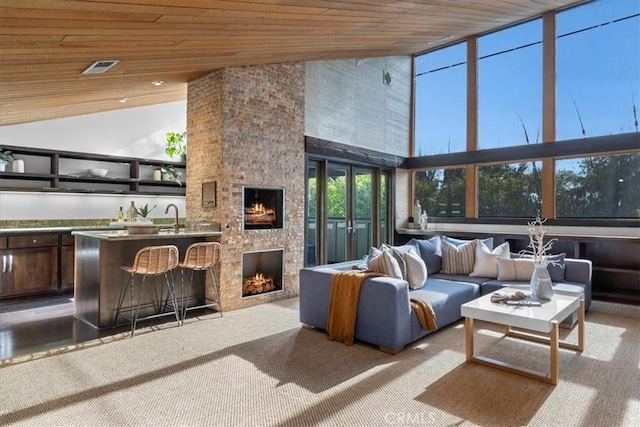 sunroom / solarium with wood ceiling, indoor wet bar, a sink, and a lit fireplace