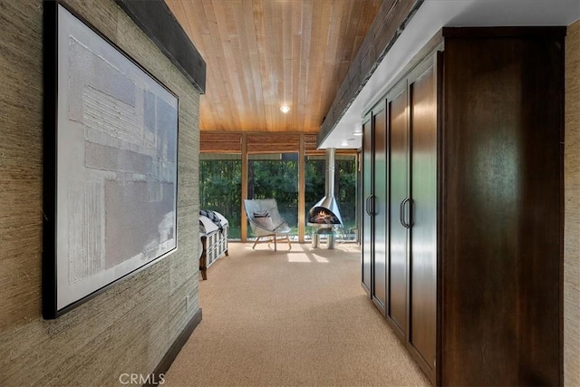 hallway featuring a sunroom, wooden ceiling, and light carpet