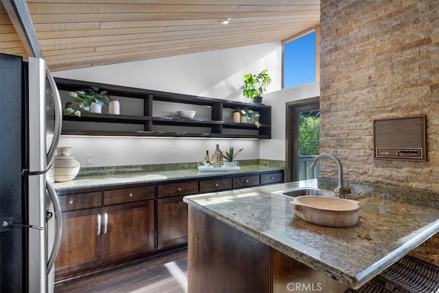 kitchen featuring open shelves, freestanding refrigerator, a sink, dark brown cabinets, and wooden ceiling