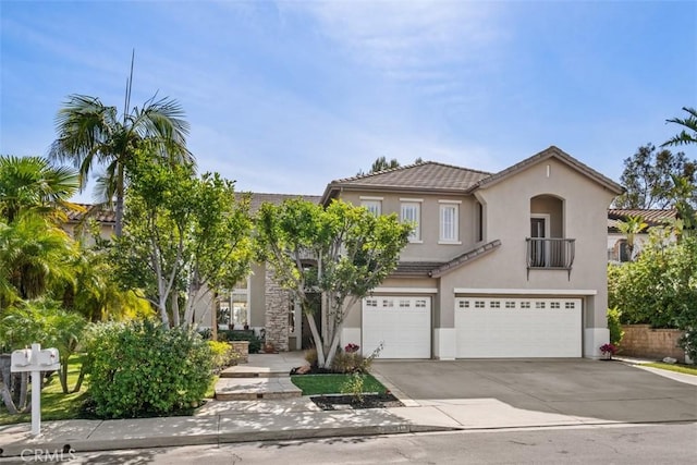 mediterranean / spanish home with a garage, driveway, a tiled roof, and stucco siding