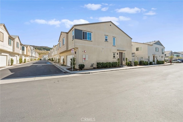 view of street featuring a residential view, curbs, and sidewalks