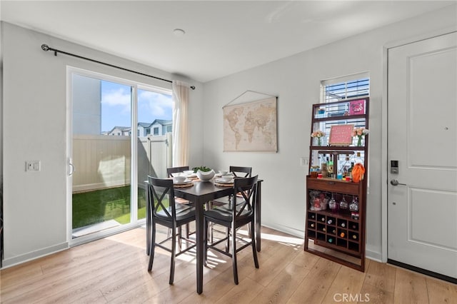 dining space with light wood-style flooring and baseboards