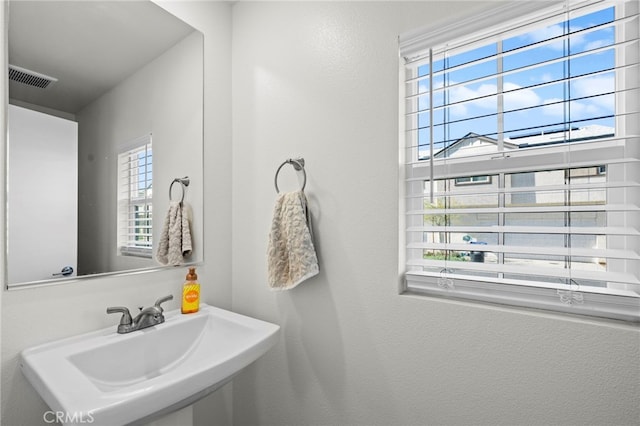 bathroom featuring plenty of natural light, visible vents, and a sink