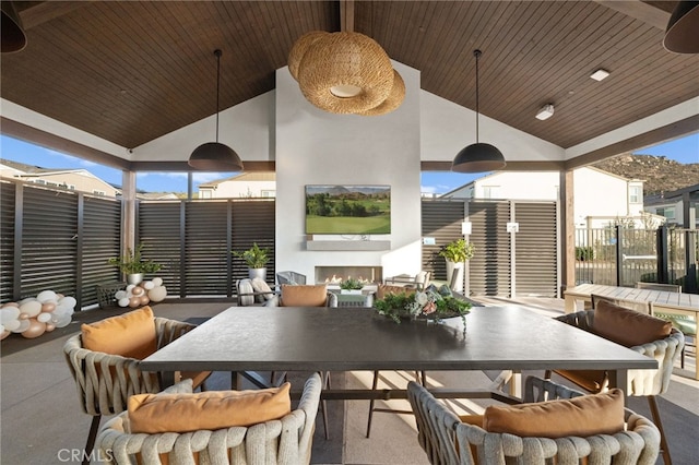 view of patio featuring a lit fireplace and outdoor dining space