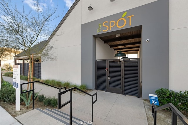 exterior space with a gate and stucco siding