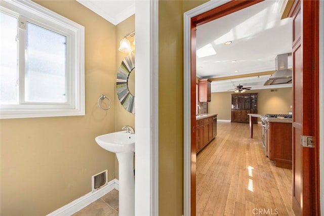 bathroom featuring wood finished floors, a ceiling fan, a sink, visible vents, and baseboards