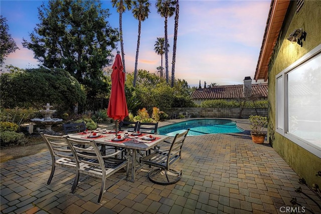 view of swimming pool featuring a fenced in pool, outdoor dining space, a patio area, and fence