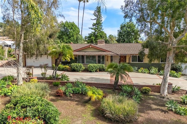 ranch-style home with an attached garage and a chimney