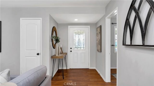 foyer entrance featuring baseboards, wood finished floors, and recessed lighting