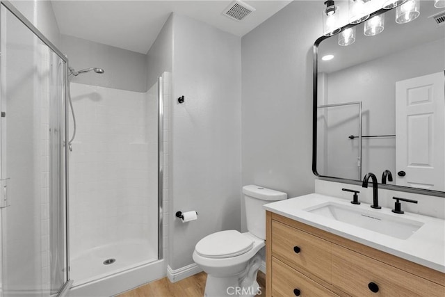 bathroom with toilet, a stall shower, visible vents, and vanity