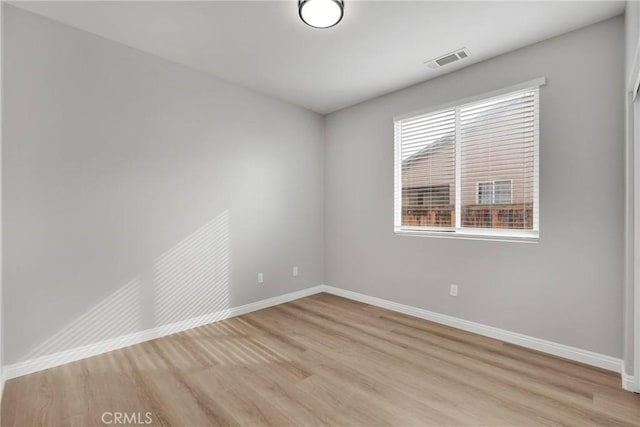 unfurnished room featuring light wood-style floors, baseboards, and visible vents