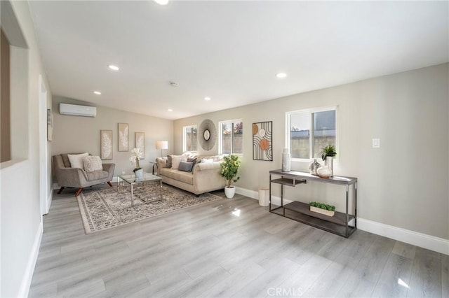 living room featuring light wood-style floors, recessed lighting, a wall unit AC, and baseboards