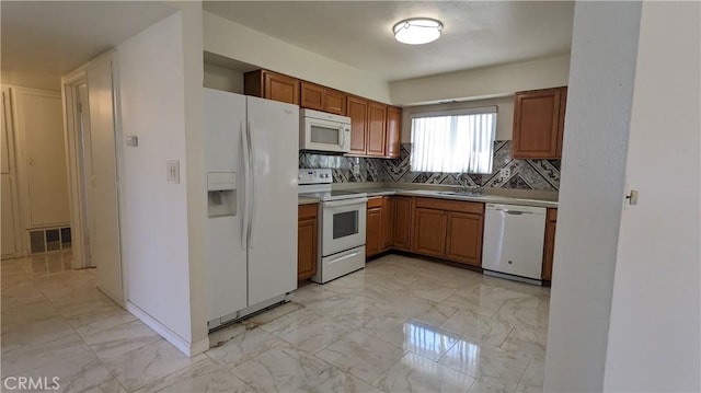 kitchen with white appliances, visible vents, brown cabinetry, marble finish floor, and light countertops