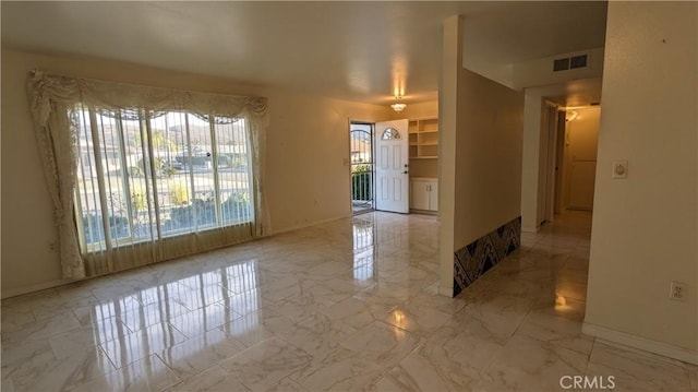 spare room featuring marble finish floor, visible vents, and baseboards