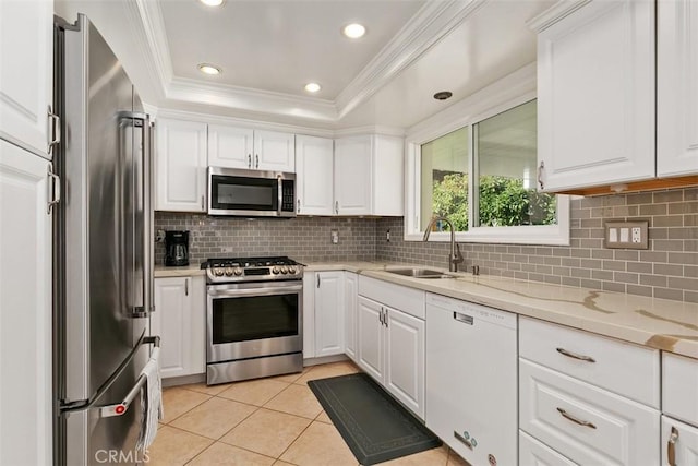 kitchen featuring white cabinetry, stainless steel appliances, a sink, and a raised ceiling